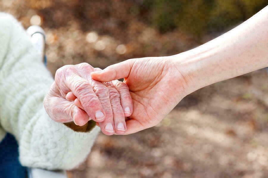 Die Hand eines alten Menschen wird von einer jngeren Hand gehalten.