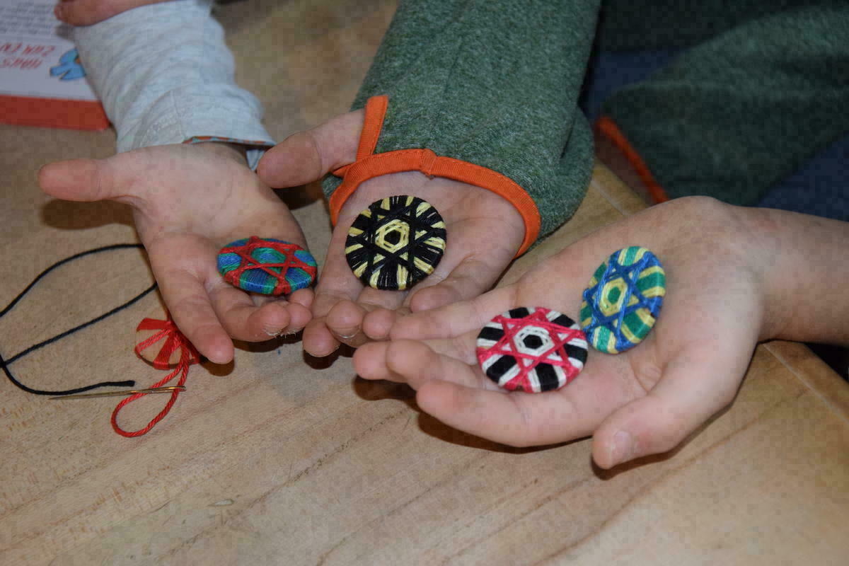 bunt umwickelte runde Posamentenknöpfe in Kinderhänden