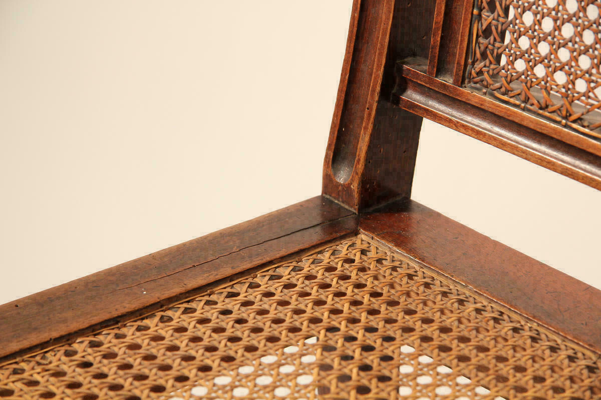 Detail eines Stuhles mit geflochtenem Sitzteil.