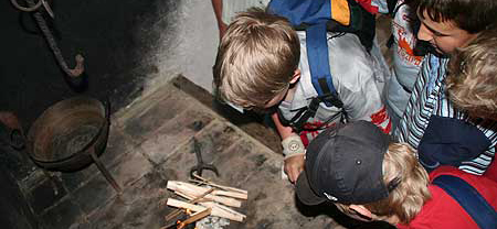 zwei Kinder blicken auf einen kleinen Stapel mit Anschürholz