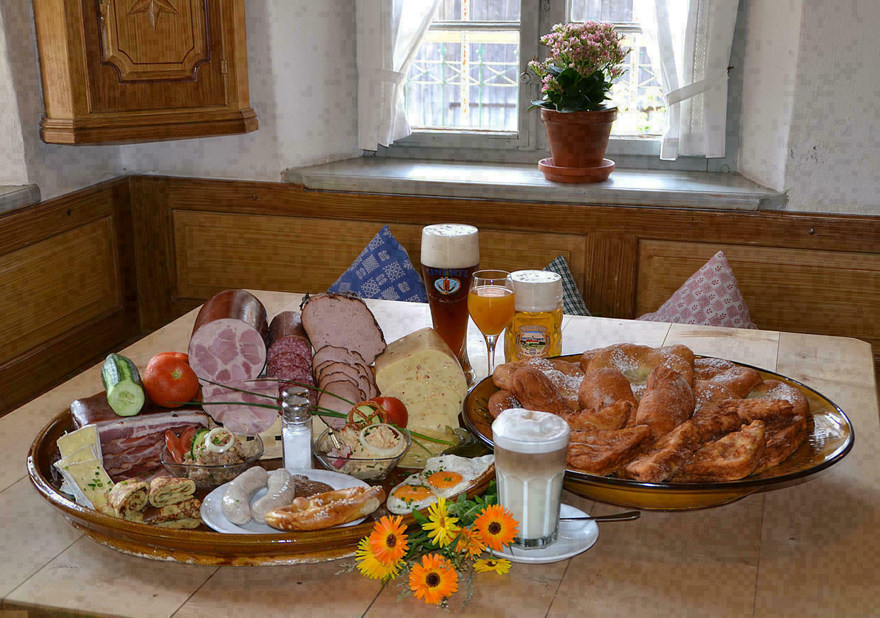 Ein reich gedeckter Tische mit Wurst, Käse, Bier, Latte Macchiato, Auszognen etc.