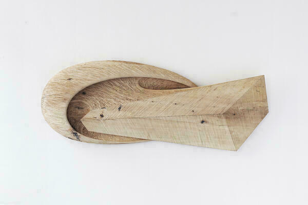 Ein von Heiko Börner hergestelltes Kunststück aus Holz in einer ungewöhnlichen geometrischen Struktur: Vorne ist es rund mit einem eckigen Griff.