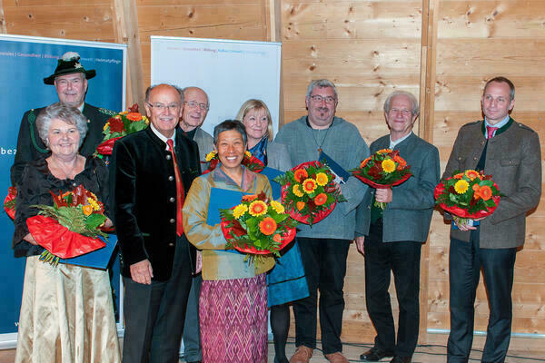 Gruppenfoto mit neun Personen, dritter von links ist Bezirkstagspräsident Josef Mederer. Ausser ihm halten alle einen Blumenstrauß in der Hand.