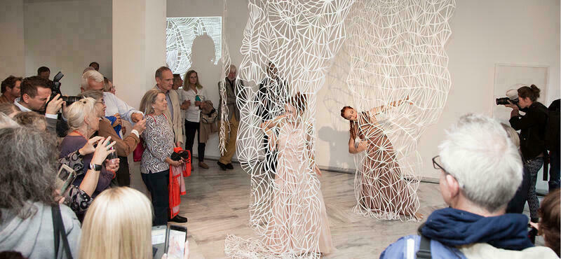 Performance während der Vernissage der Ausstellung "Ebony und Ivory". Die Performance-Künstlerinnen bewegen sich in einer Papierskulptur von Verena Friedrichs.