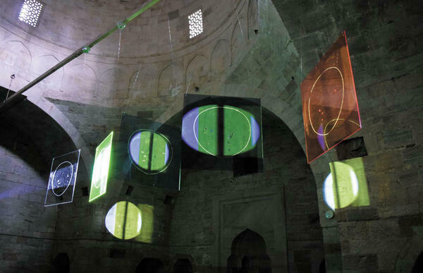 Mischa Kuball: Five Suns. After Galileo
Innenraum einer Kirche mit grünen und roten Farbscheiben in Kreisform, die ander Decke hängen