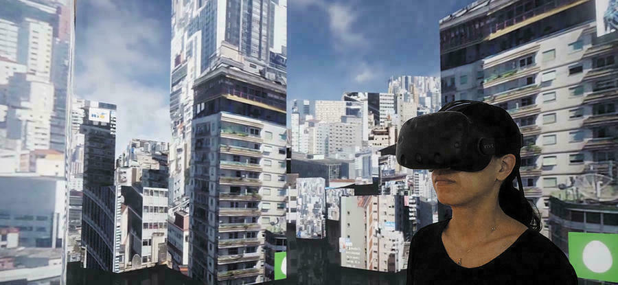 Eine Frau im einem VR-Headset steht inmitten einer virtuellen Landschaft aus Hochhäusern