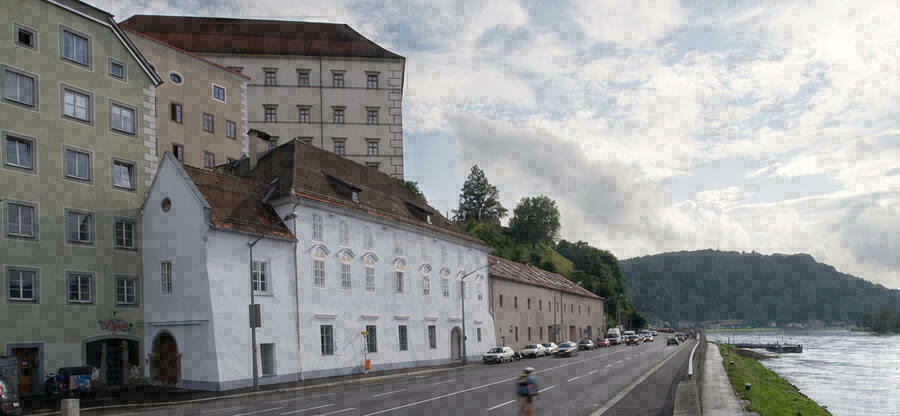 Blick eine Straße hinab; auf der linken Seite Gebäude und auf der recten Seite ein Fluß
