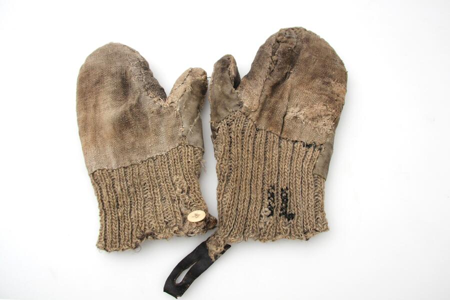 Ein Paar Handschuhe: Die Fäustlinge sind mehrfach ausgebessert, geflickt, mit Ersatzstoff versehen etc.