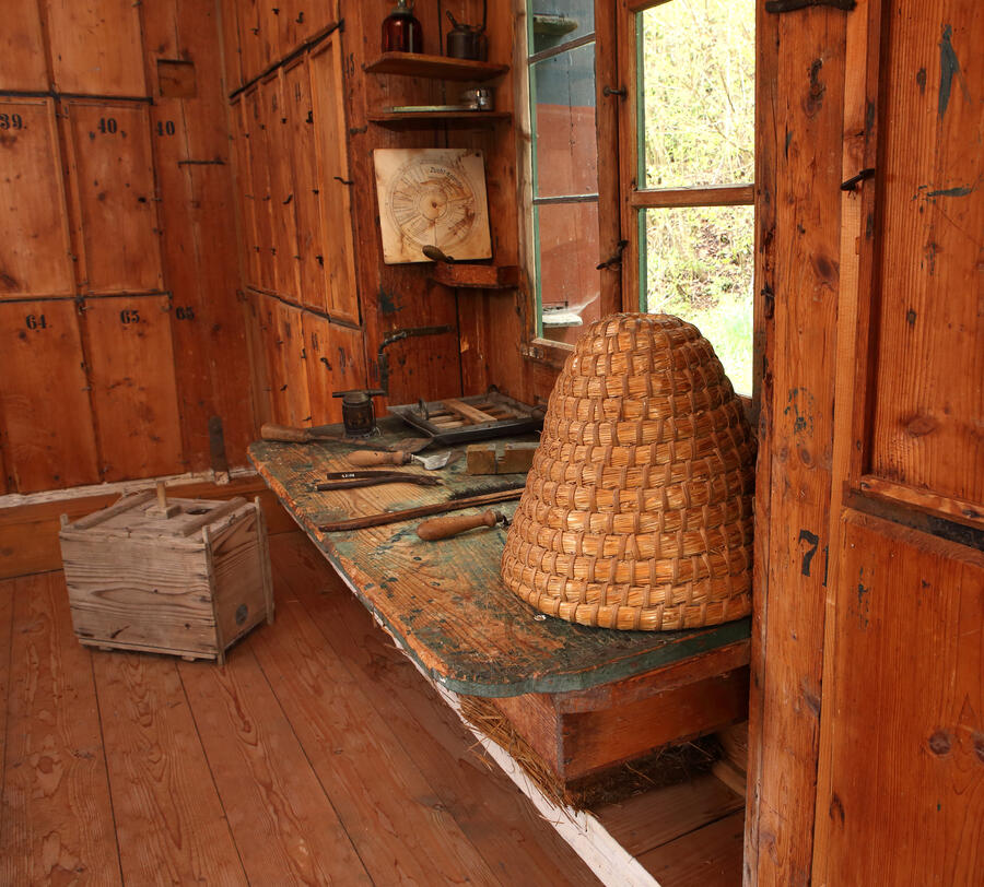 Vor einem Fenster stehen verschiedene Geräte, die der Imker für das Arbeiten mit Bienen benötigt.