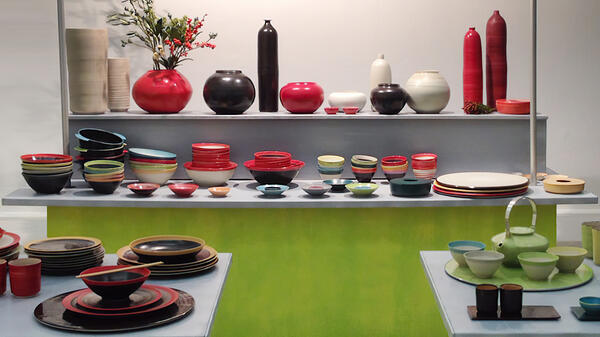 Zu sehen ist eine Ausstellung mit Haushaltskeramik, Schüsseln, Teller, Vasen in unterschiedlichen Größen, Farben und Formen.