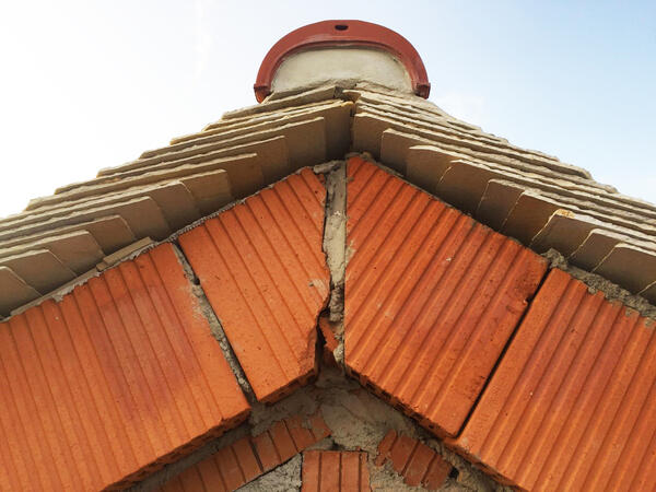 Dachgiebel mit roten Ziegeln und hellbraunen Juraschieferplatten
