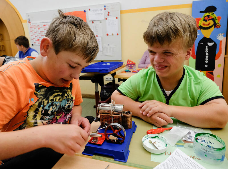 Zwei Schüler der Johann-Nepomuk-von-Kurz Schule (Förderzentrum Förderschwerpunkt körperliche und motorische Entwicklung) arbeiten im Unterricht an einem mechanischen Experiment