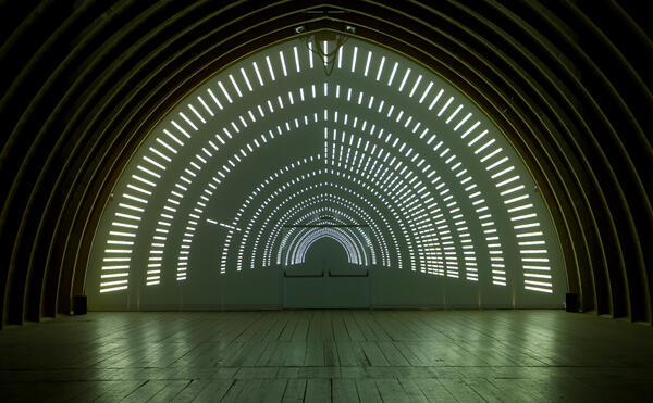 Kunst / Videoinstallation: Auf der Querwand des Tonnengewölbes werden mit Licht viele Linien projiziert