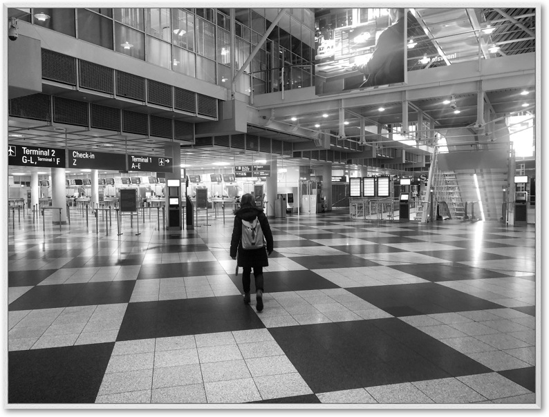 SW-Foto: Ein Mensch von hinten in einm leeren Flughafen-Terminal