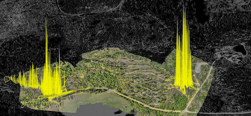 Grafik aus Landkartenteilen und gelben Spitzen vor schwarzem Hintergrund