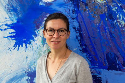 Frau vor einem abstrakten Gemälde in blau