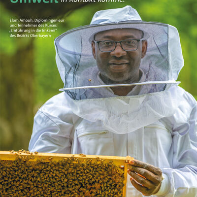 Seite aus der Broschüre "Im Portrait": Ein Imker in Arbeitskleidung hält eine Wabe mit Bienen in der Hand und sieht den Betrachter an.