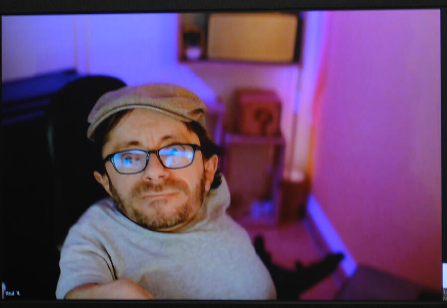 Ein Mann mit Mütze und Brille blickt in die Kamera.