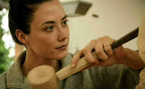 Eine junge Holzbildhauerin aus den Schulen für Holz und Gestaltung in Garmisch-Partenkirchen bearbeitet bei ihrer praktischen Gesellenprüfung eine Holzskulptur.