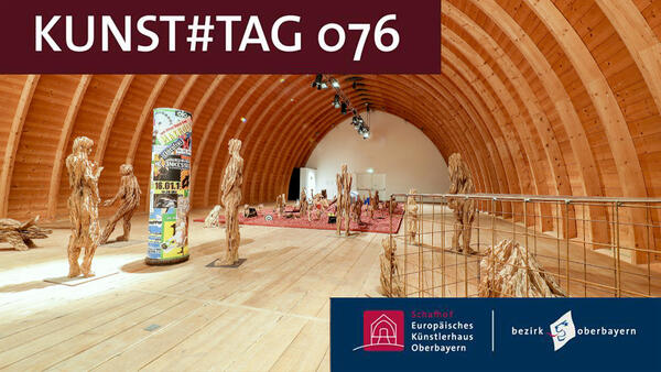 In dem mächtigen Tonnengewölbe des Schafhofs sieht man aus Holzstämmen gesägte Figuren, die Teil der Ausstellung 